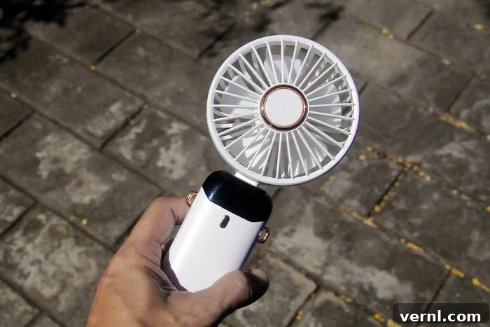 Don't Sweat Your Summer DIY Essential Cooling Tools 6 Man using a rechargeable clip-on fan attached to his tool belt while doing home maintenance to stay cool