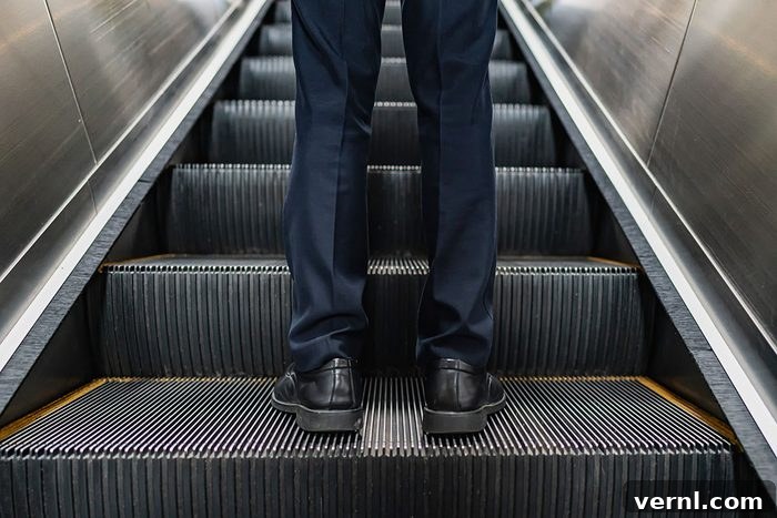 Close-up of feet of business people standing on escalator with brushes clearly visible