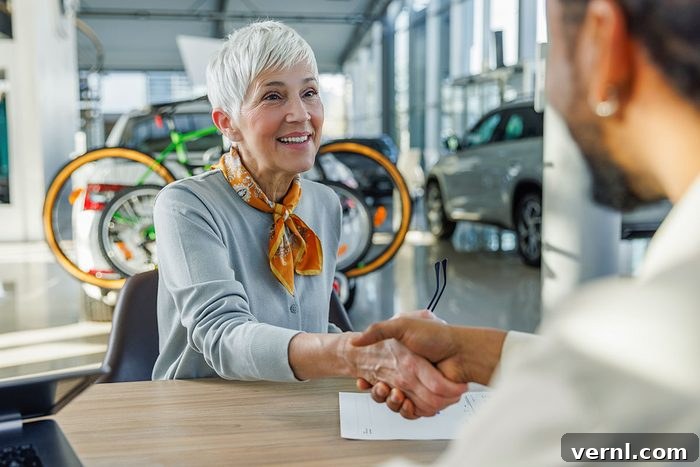 Navigating Your Car Dealership's Collapse 2 Happy senior woman shaking hands with salesperson at desk in car showroom