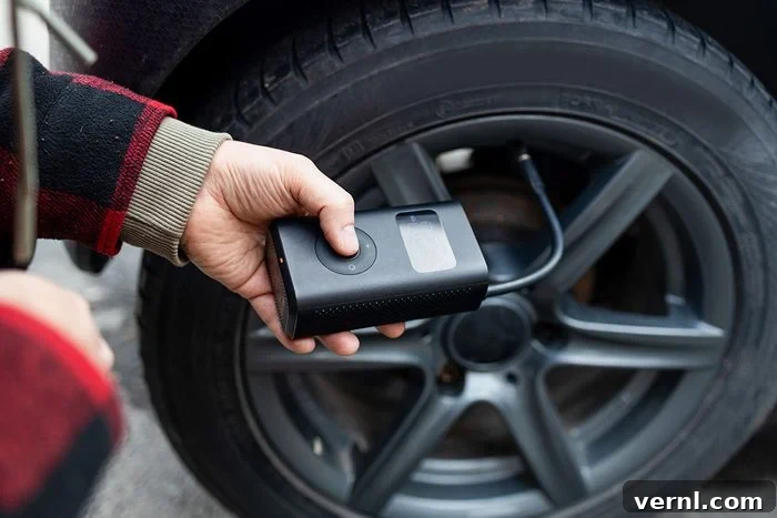 Free Air for Your Tires: Your Guide to Finding It 2 Man using portable air compressor to inflate car tires
