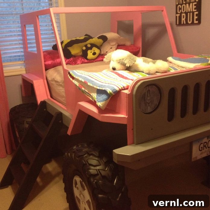 Girl smiling in her pink custom-built Jeep bed, showcasing the versatile design for all children