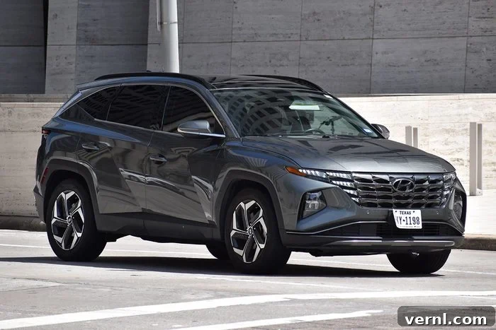 Top Cars of 2025: A Year of Triumphs 5 A gray Hyundai Tucson SUV traveling near an office building