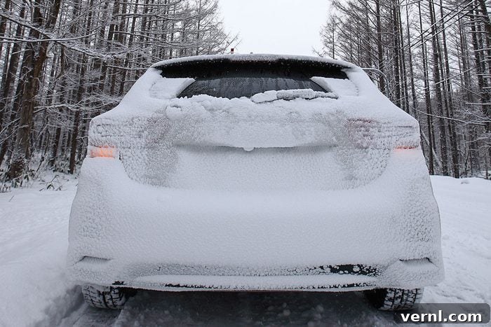 Snow covered vehicle on country road through forest in winter