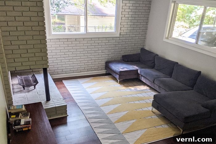 A dimly lit, unfinished basement with concrete floors and exposed pipes before renovation.