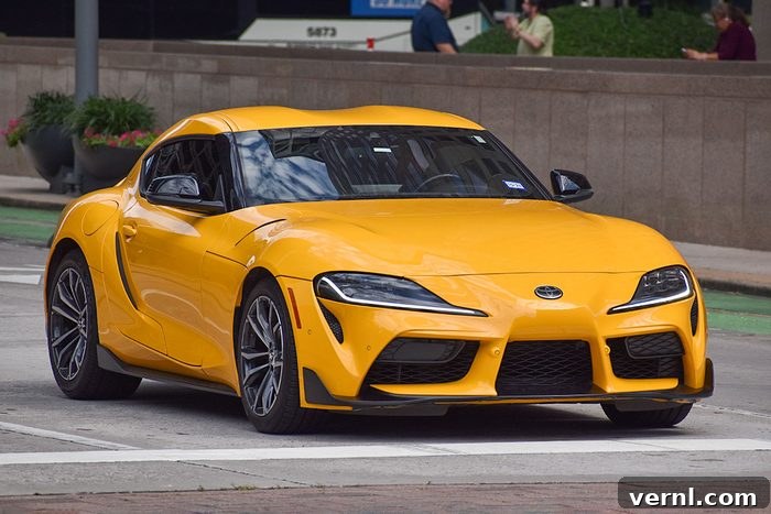 Shifting Against the Tide: Which Automakers Still Offer Manuals in 2026 3 A portrait of a yellow Toyota GR Supra 2 sports car cruising in a downtown district