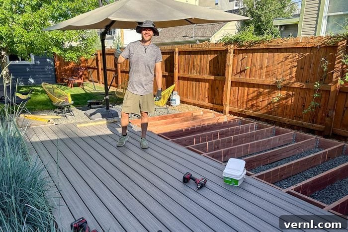 Father and Son Build a Stunning Deck in Just One Week 3 Man in a sun hat standing on boards of a semi-finished deck in backyard