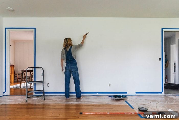 Woman Standing Painting Wall At Home