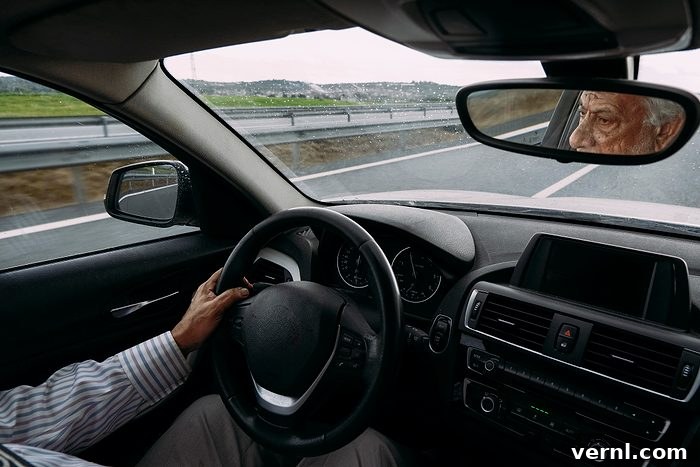 Senior businessman driving a car on a rainy day