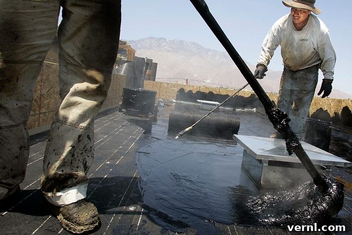 Luis Orozco, left and Martin Guerra are tarring a roof at a new development in Palm Springs, California