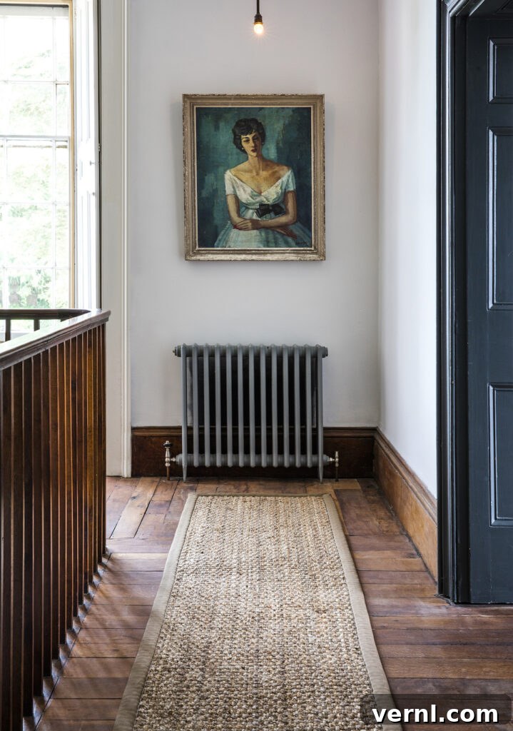 Hallway, Staircase and Landing Design Ideas for an Elegant Home 8 A staircase landing with wood floors, a textured runner, and a vintage painting.