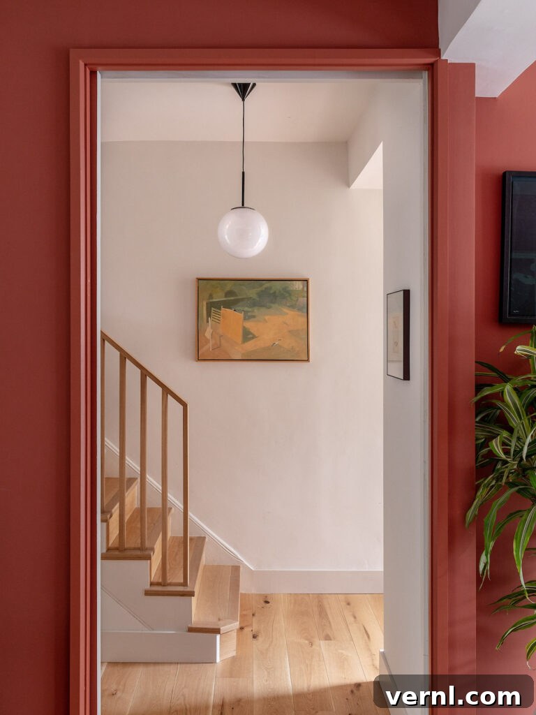 Hallway, Staircase and Landing Design Ideas for an Elegant Home 10 Warm terracotta entryway with minimalist staircase featuring light wood tones and a simple hanging globe light.