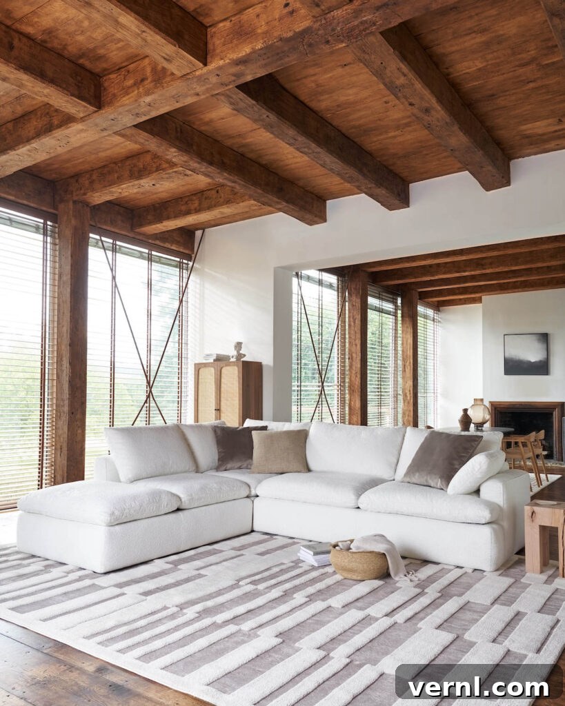 Cream corner sofa in a modern rustic living room with wooden beams, neutral decor, and soft boucle texture.