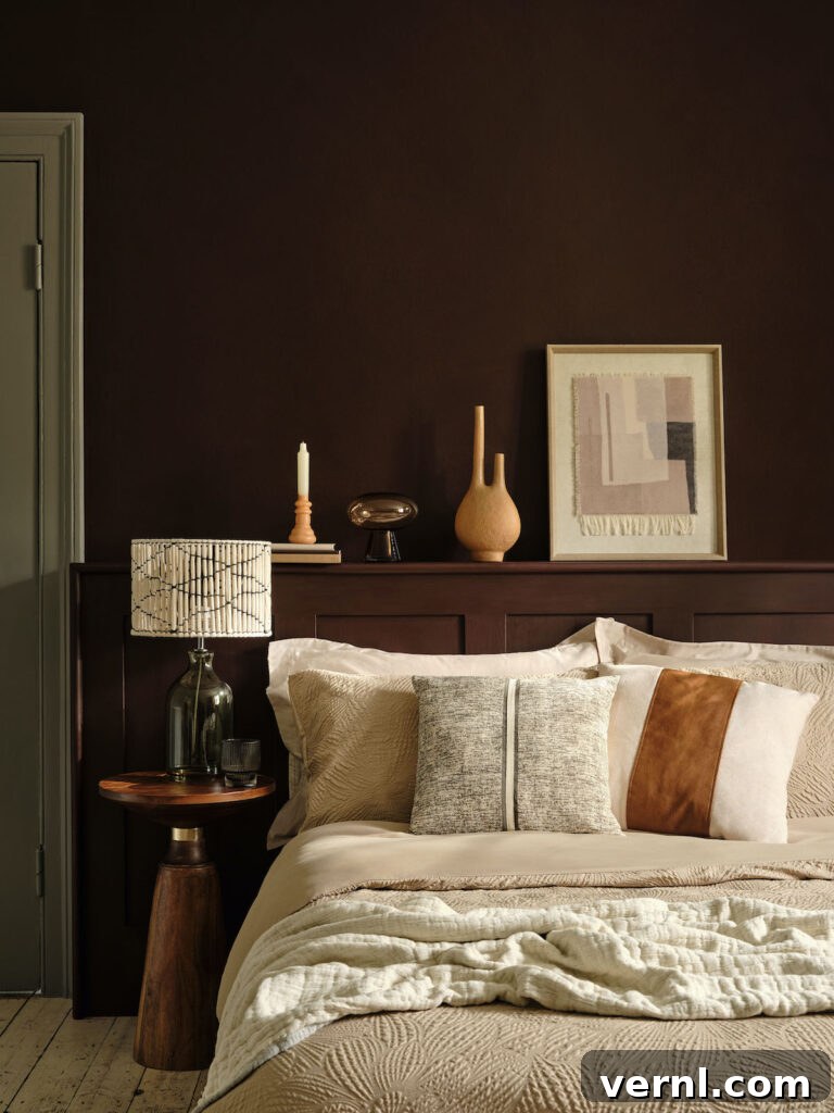 A cosy bedroom with the bed decorated in lots of soft cushions and the walls painted in a rich earthy tone.