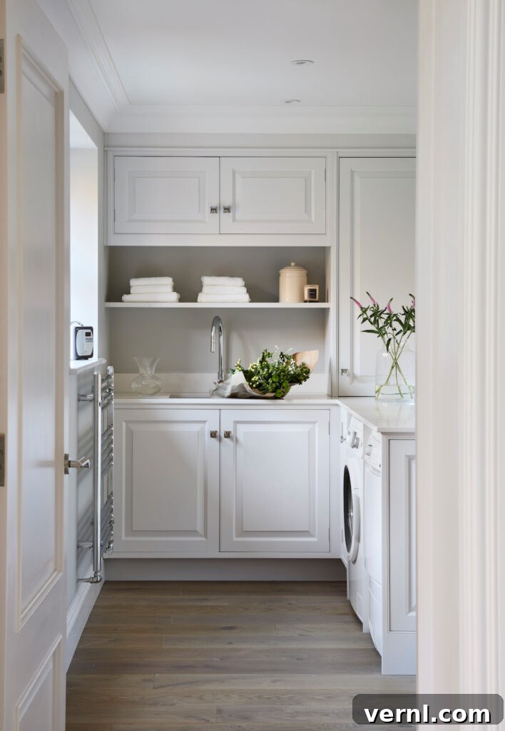 Why Homeowners Move Laundry Rooms Upstairs — And You Should Too 3 A bespoke utility room featuring handmade overhead and undercounter cabinetry with decorative open shelving and freestanding appliances, handpainted in Blackened by Farrow & Ball.