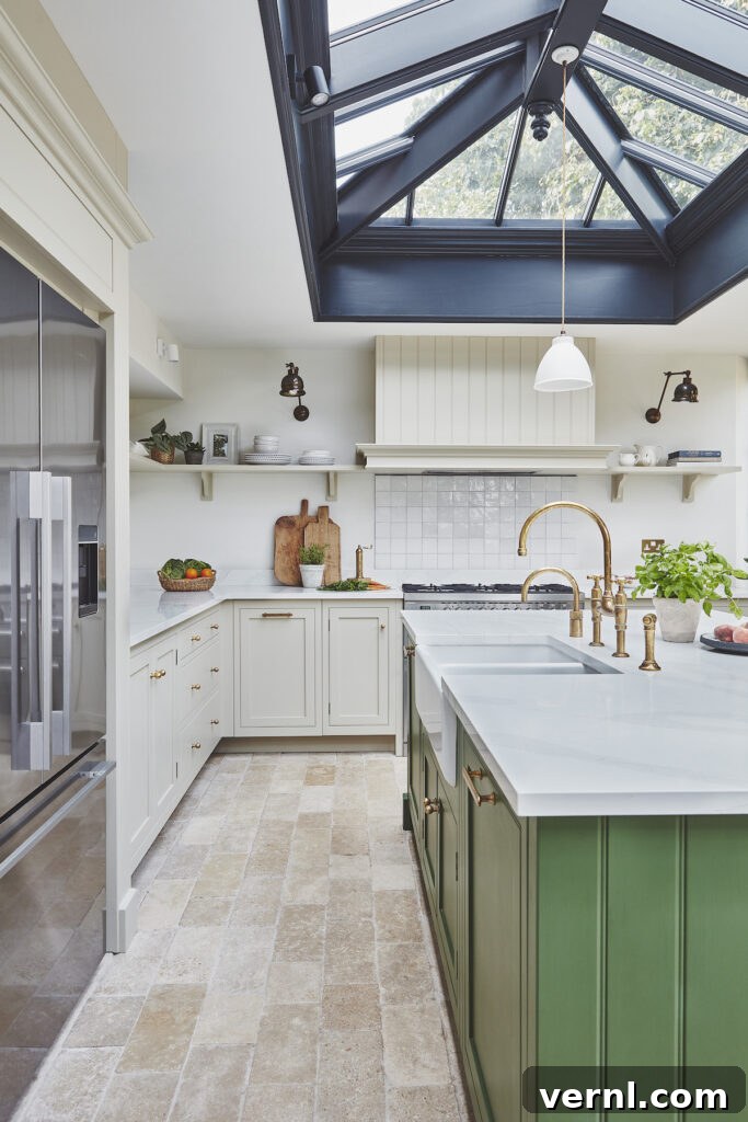 A large cream kitchen with a green kitchen island and large lantern roof light.