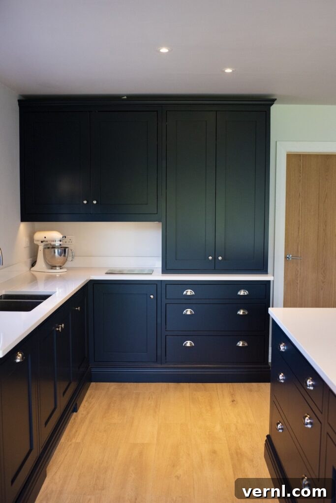 10 Clever Small Kitchen Ideas to Maximize Space and Function 2 A dark blue Shaker style kitchen with cabinets stretching up to the ceiling, showcasing small kitchen ideas.