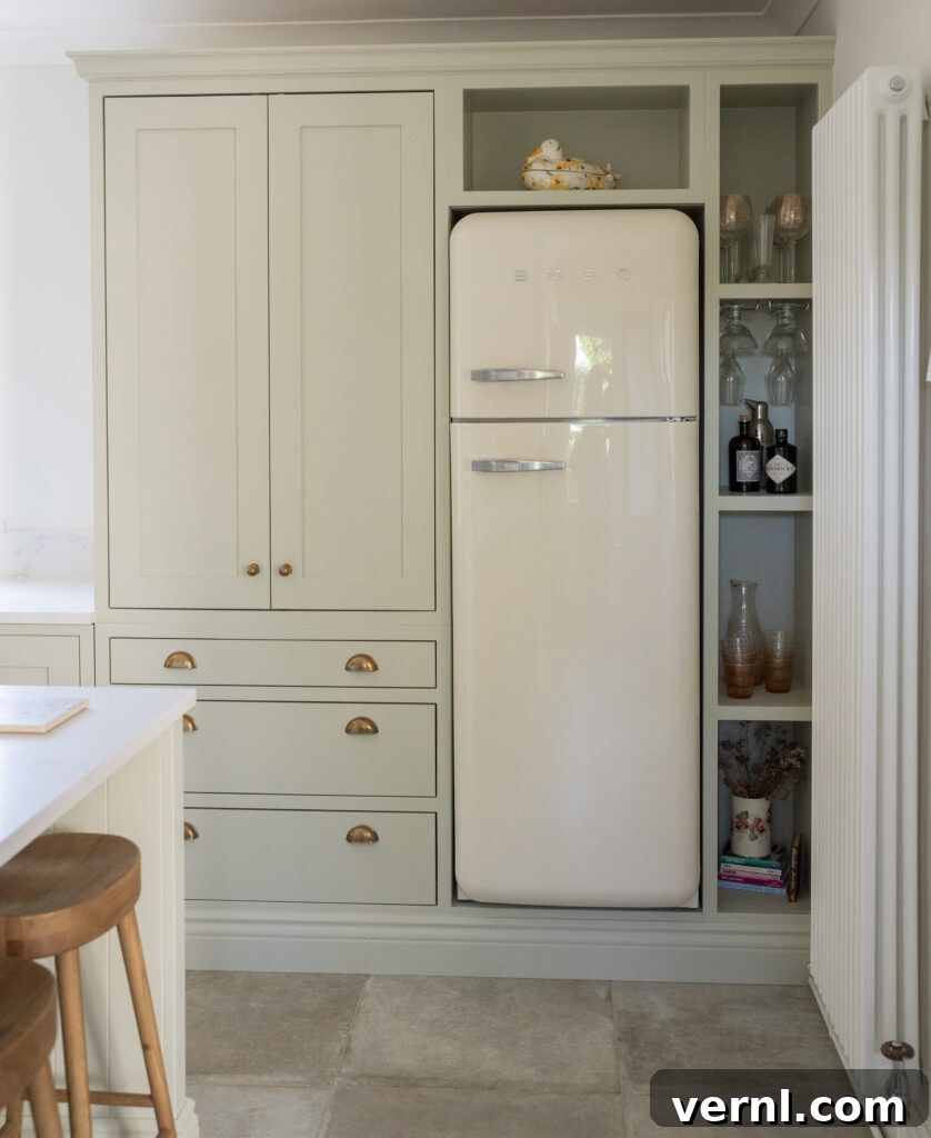 10 Clever Small Kitchen Ideas to Maximize Space and Function 6 "Small kitchen with built-in sage green cabinets, brass hardware, and a retro cream fridge.