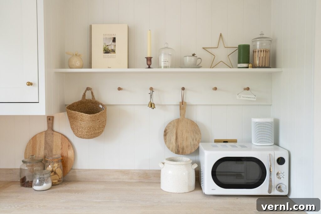 10 Clever Small Kitchen Ideas to Maximize Space and Function 8
A cozy small kitchen featuring white cabinetry, wooden countertops, and functional hooks and a pegboard for hanging baskets and utensils, offering practical small kitchen ideas.