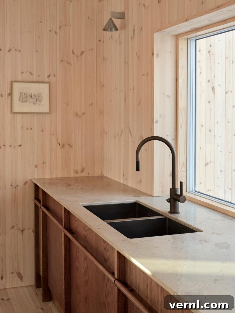 Modern Mountain Cabin: A Stunning Design Retreat 4 Close-up of wood kitchen cabinets with a sleek black sink and faucet, set against light wooden walls.