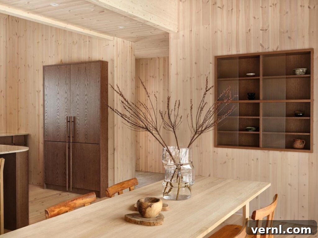 Modern Mountain Cabin: A Stunning Design Retreat 5 Bright dining area in a mountain home with natural wood finishes, modern cabinetry, and a minimalist decor.