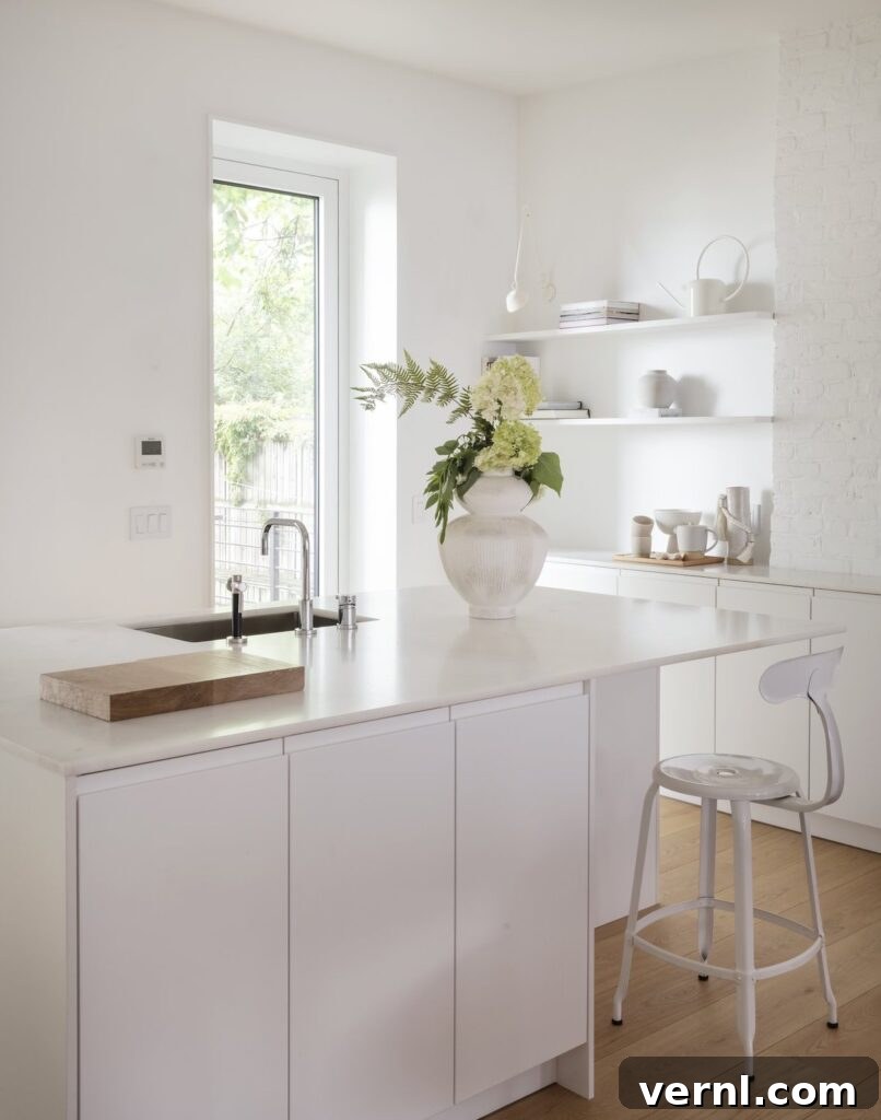 Brooklyn Row House Renovation for Modern Family Living 2 White minimalist kitchen with sleek cabinetry, open shelving, and natural light.