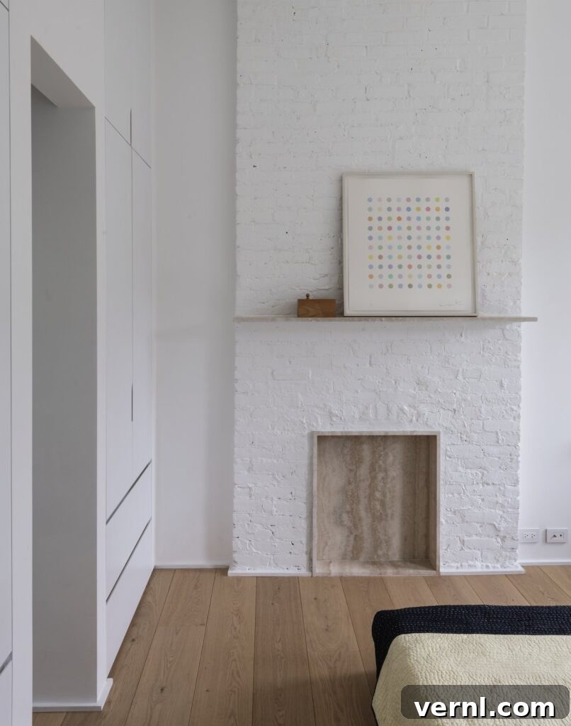 Brooklyn Row House Renovation for Modern Family Living 14
White painted brick chimney breast with minimalist mantel and abstract artwork.