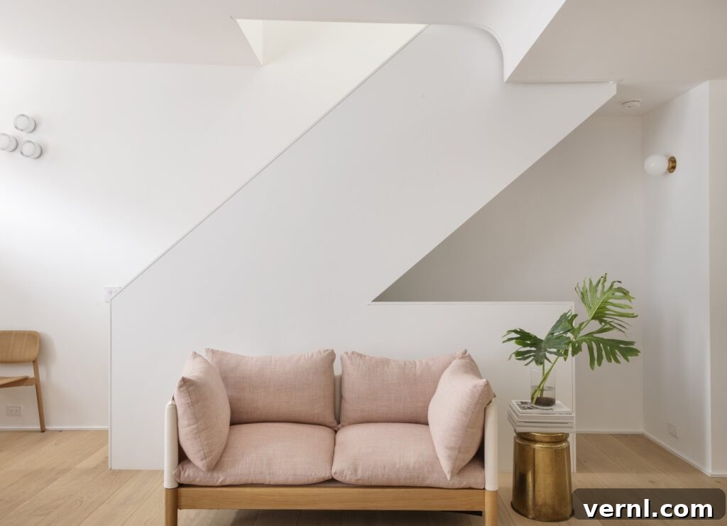 Brooklyn Row House Renovation for Modern Family Living 15
Minimalist living room with blush pink sofa and sculptural angular staircase.