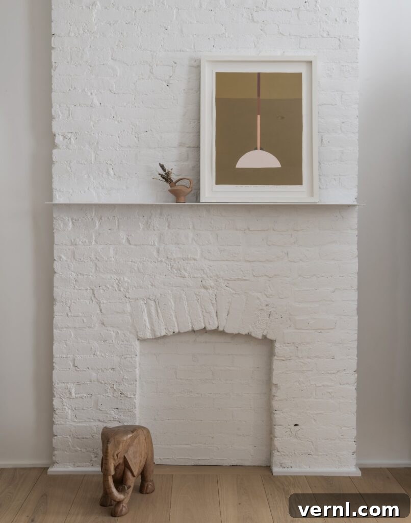 Brooklyn Row House Renovation for Modern Family Living 16
White painted brick chimney breast with framed art and wooden elephant sculpture.