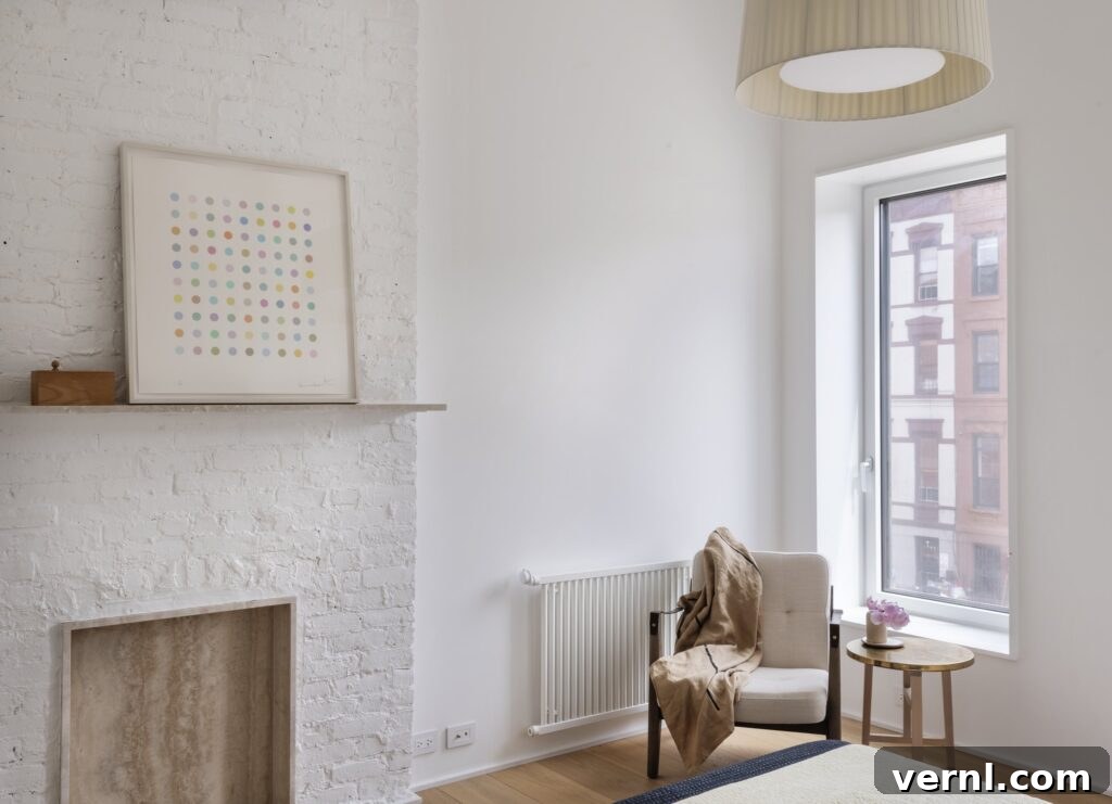 Brooklyn Row House Renovation for Modern Family Living 17
White minimalist living room with painted brick chimney breast and modern armchair.