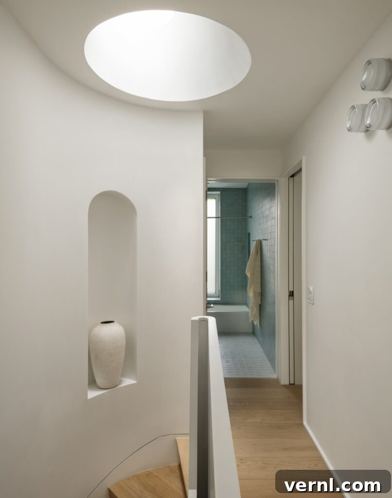 Brooklyn Row House Renovation for Modern Family Living 5
Curved staircase landing with skylight and built-in alcove vase, leading to tiled bathroom.