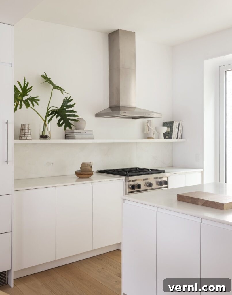 Brooklyn Row House Renovation for Modern Family Living 9 White minimalist kitchen with sleek cabinetry, stainless steel hood, and open shelving.