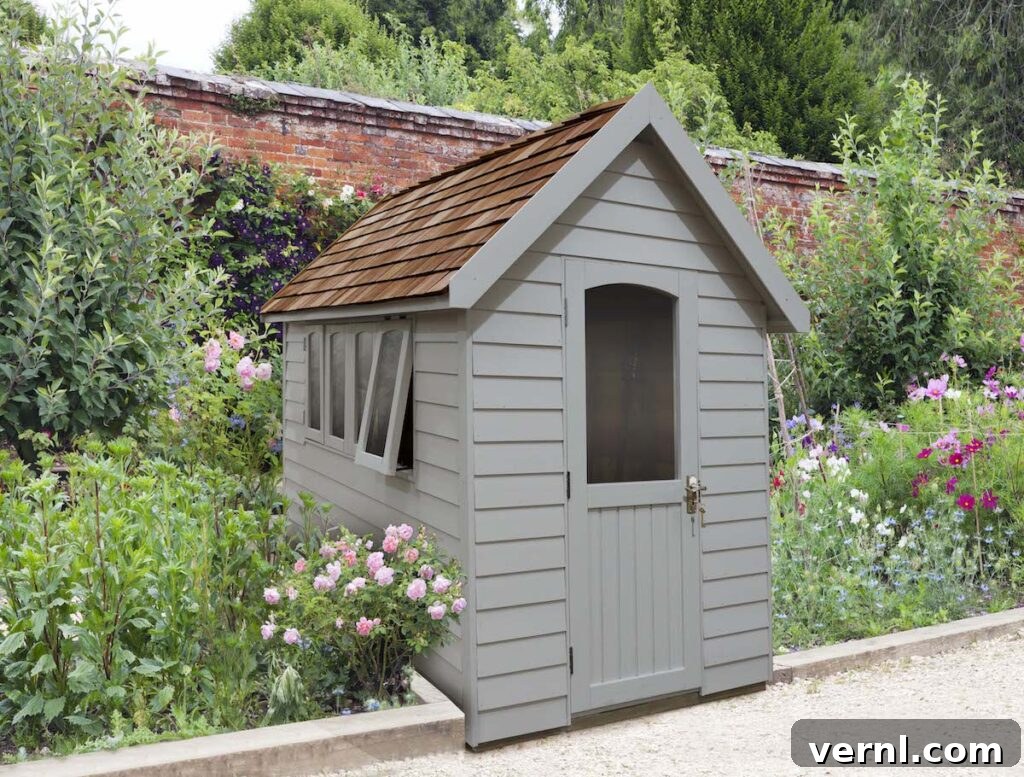 Shed Color Trends 2025 Popular Shades Homeowners Choose 4 A grey garden shed in a romantic garden with pink roses.