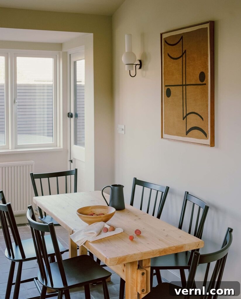 Inside a Dorset Beach House: Modern Coastal Living 7 Rustic pine dining table with black chairs and abstract wall art