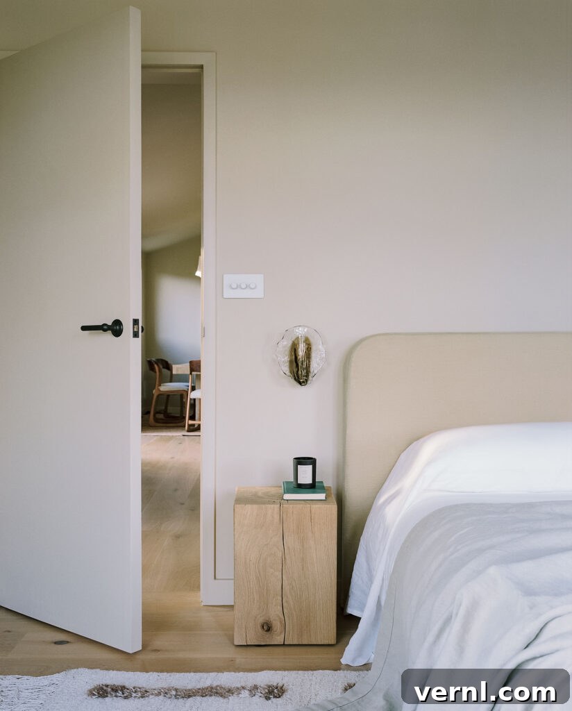 Inside a Dorset Beach House: Modern Coastal Living 10 Minimalist bedroom corner with wood nightstand and soft neutral bedding.